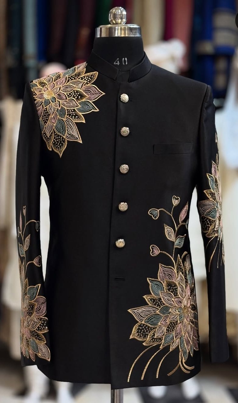 A black bandhgala with gold floral embroidery across the hem