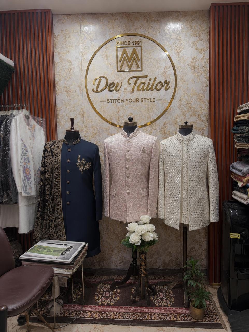 Inside the shop: mannequins in sherwanis beneath the Dev Tailor wall mark, Stitch Your Style, since 1991