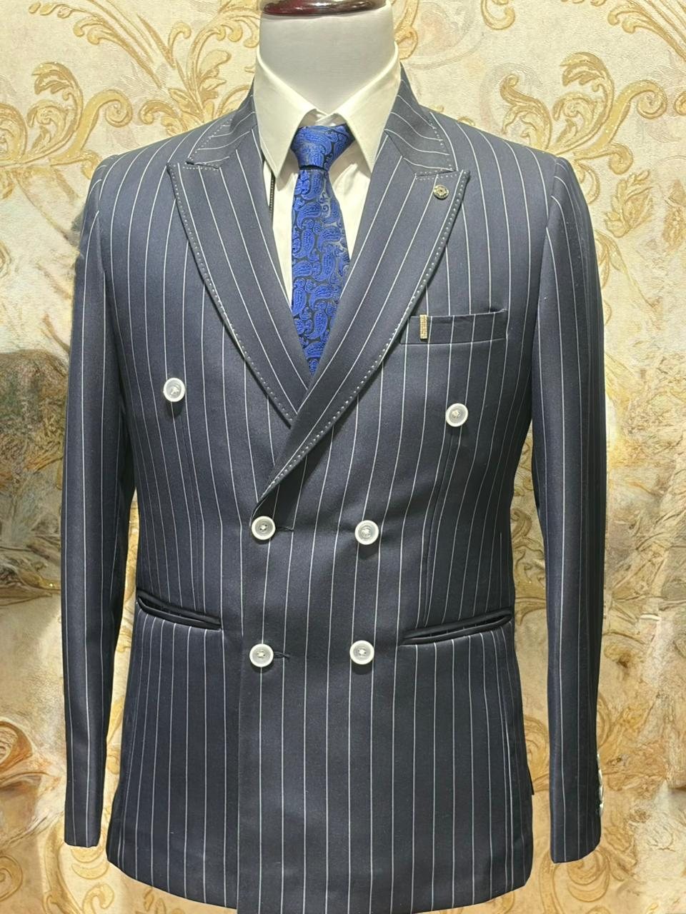 A grey pinstripe double-breasted suit with a blue tie