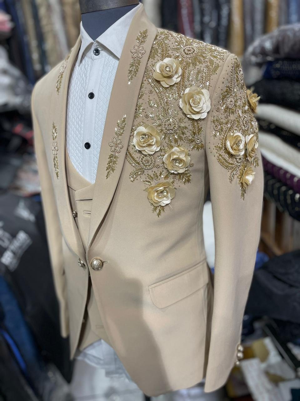 A cream tuxedo with three-dimensional floral work on the shoulder